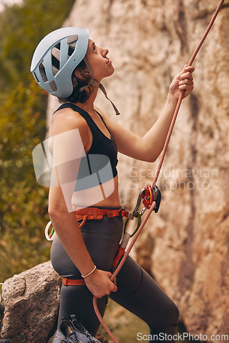 Image of Rope, rock climber and woman mountain climbing in nature for exercise, endurance and body training outdoors. Fitness, challenge and fearless girl ready to climb a rocky cliff on a dangerous adventure
