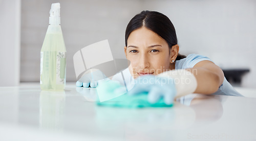 Image of Kitchen, product and cleaner cleaning a table with dirt or dust with detergent, cloth and gloves. Woman maid, domestic employee or housewife doing housekeeping in a modern office or house.