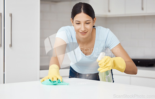 Image of Cleaning service, table and cleaner in the kitchen working with spray bottle to scrub messy dirt with a cloth and soap detergent. Happy, woman and employee on housekeeping job in gloves with products