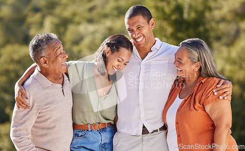 Image of Happy, hug and smile, an adult family in a park standing together. Mother, father grown up kids laughing. Happiness, love and nature, man and woman with senior couple in nature at an outdoor event.