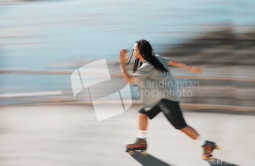 Image of Fitness, exercise and a man on roller skates moving fast with blurred background. Action, movement and an adrenaline rush skating in road. Speed, sports and a dreadlocks skater having fun in the sun.
