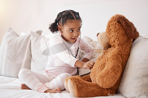 Image of Learning child with stethoscope check teddy bear with love, healthcare or child development in her bedroom. Smart girl or baby with doll in play pretend game for fun, healthy mind and education