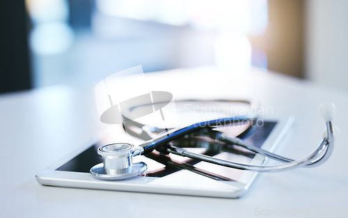 Image of Digital tablet, stethoscope and telehealth consulting on table in empty hospital, wellness and medicine insurance room. Zoom on medical equipment, healthcare research and internet technology for help