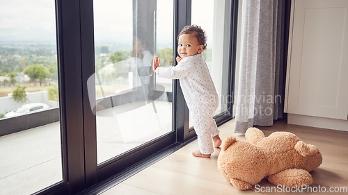 Image of A baby by window, learning and walking for child development. Baby girl, toddler and young kid standing with support to learn and develop walking skills. Help, first steps and teaching in childcare