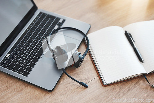 Image of Laptop, notebook and headphones for call center, customer service and crm consulting in empty contact us office. Zoom on communication technology for internet webinar, training and education workshop