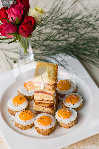 Image of A Starter Of Mini Fried Quail Eggs And Sweet Back Bacon Sandwich