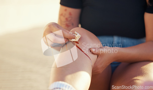 Image of Knee injury and person cleaning blood wound with tissue to stop bleeding for healing and recovery. Self care hygiene after accident with torn and sore skin on leg for infection prevention.