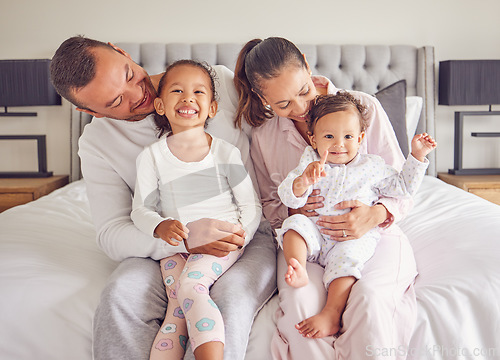 Image of Family, bonding and bed time with children and parents smile and rest together, loving and caring in bedroom. Play, sleep and routine by young man and woman enjoy the morning with happy girl in home