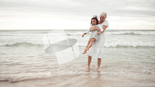 Image of Grandmother, beach fun and child in happy bonding time together outside in nature. Elderly woman holding little girl in playful family bond at the ocean on holiday vacation in the outdoors