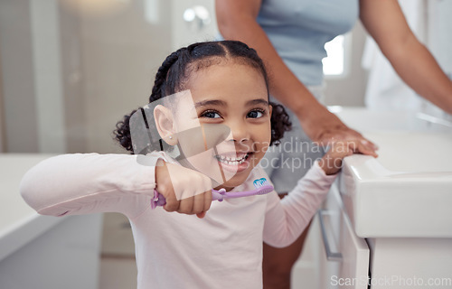 Image of Children, toothbrush and toothpaste with a girl brushing teeth in the bathroom at home for dental hygiene or care. Healthcare, teeth and mouth with a cute female child practicing good oral habits