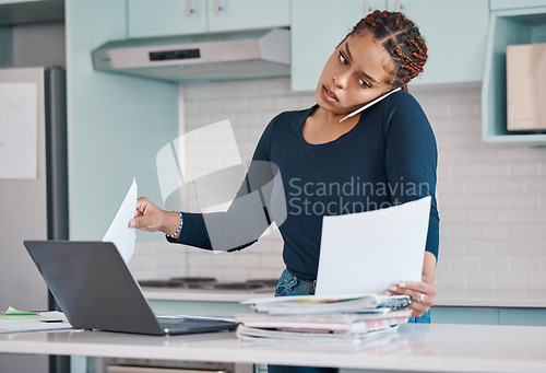 Image of Black business woman working from home in freelance, multitasking paperwork with laptop and mobile audio phone call. Internet technology in kitchen, consulting invoice documents in covid pandemic