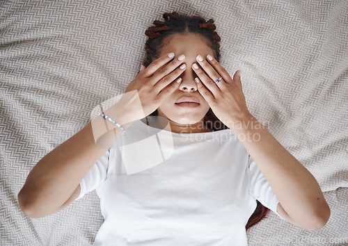 Image of Stress, anxiety and black woman using hands over eyes to calm, relax and peace in bed. Stress management, mental health and insomnia with sleepless young female lying in bedroom for depression