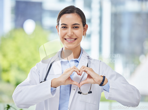 Image of Heart, hand and icon with happy doctor in medical clinic or hospital. Happy, health and safety in the field of medicine and healthcare while love for her career, job or work while ready to help