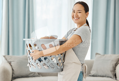 Image of Happy Asian cleaner woman with laundry working for home, house or hotel hospitality cleaning help service agency. Japanese girl maid or worker smile in apartment with dirty clothes in washing basket