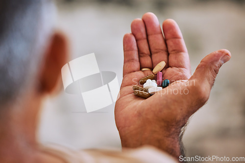 Image of Senior hand of man with pills, medicine or medication for disease, cancer or health at home. Wellness, healthcare or sick elderly retired person with medical drugs, aspirin or antibiotics in palm.