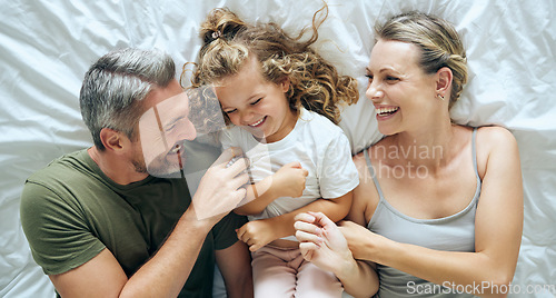 Image of Bed, love and family bonding, relax and having fun laughing and being playful in a bedroom together from above. Smile, play and happy child enjoy waking up in morning with playful, young parents