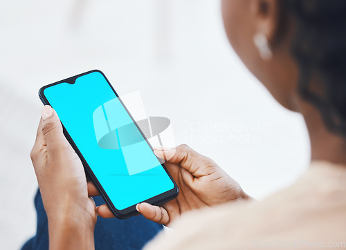 Image of Woman on a phone with green screen networking on social media or reading online blog on website. Closeup of african hands holding smartphone while browsing on internet or mobile app while relaxing.