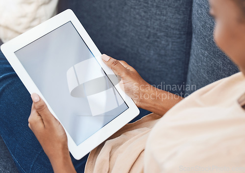 Image of Mockup digital tablet, in hands of black woman on couch in a living room in her house and goes online to find entertainment. Mobile technology is used for social media, e-commerce and video call