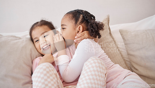 Image of Girl, friends or children whisper secret to best friend on home sofa while relax together on play date. Communication, conversation and sisters or youth kids gossip at fun slumber party or sleepover
