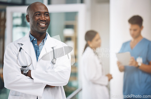 Image of Medical, healthcare and arms crossed with doctor in hospital for vision, trust and leadership. Support, innovation and motivation with black man employee in medicine, surgery and first aid clinic