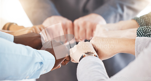 Image of Hand, collaboration and motivation with the hands of a business team together in a huddle or circle. Teamwork, goal and target with an employee group joining their fists in trust, solidarity or unity
