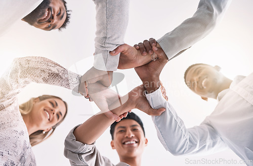 Image of Teamwork hands, wrist and unity in collaboration, motivation and support for success, vision and goals. Below of happy, diversity and solidarity staff in partnership, cooperation and trust together