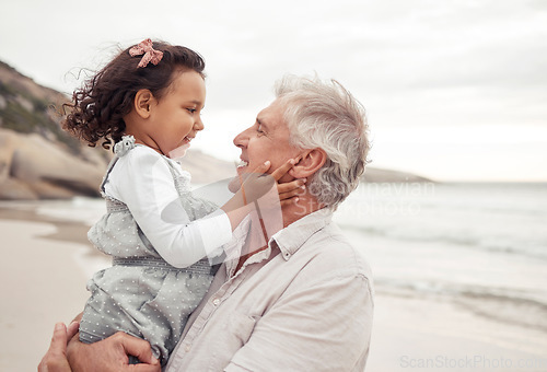 Image of Family, beach and bonding with grandfather and grandchild hug, sharing a sweet moment in nature together. Young girl holding senior man, having fun, talking and enjoying a day outdoors at the ocean
