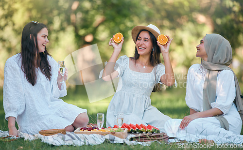 Image of Diversity, Islamic and friends on a fruit picnic on grass in nature enjoying orange, watermelon and fun jokes. Muslim, smile and happy women laughing and smiling together at a natural park for lunch