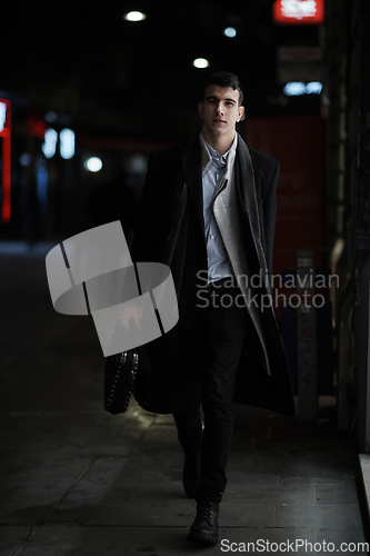 Image of Smiling Meedle Eastern man walking down street near modern office building,