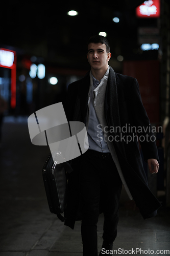 Image of Smiling Meedle Eastern man walking down street near modern office building,