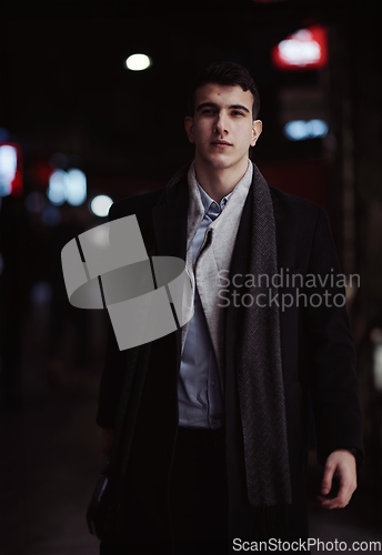 Image of Smiling Meedle Eastern man walking down street near modern office building,