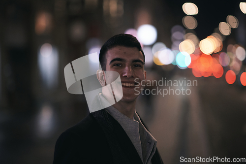 Image of Smiling Meedle Eastern man walking down street near modern office building,