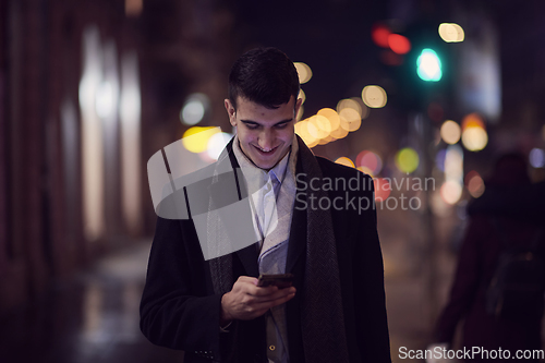 Image of Smiling Meedle Eastern man walking down street near modern office building,