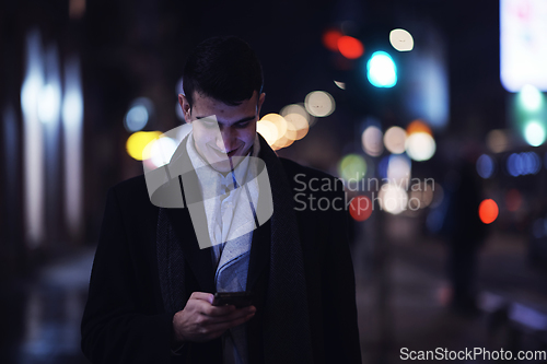 Image of Smiling Meedle Eastern man walking down street near modern office building,