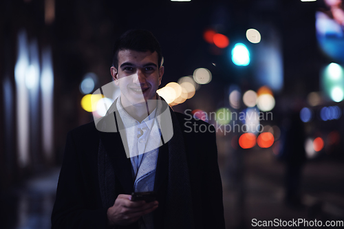 Image of Smiling Meedle Eastern man walking down street near modern office building,