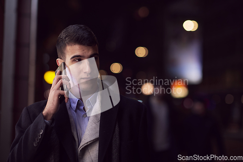 Image of Smiling Meedle Eastern man walking down street near modern office building,