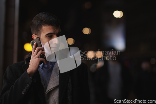 Image of Smiling Meedle Eastern man walking down street near modern office building,