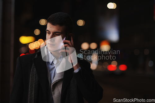 Image of Smiling Meedle Eastern man walking down street near modern office building,