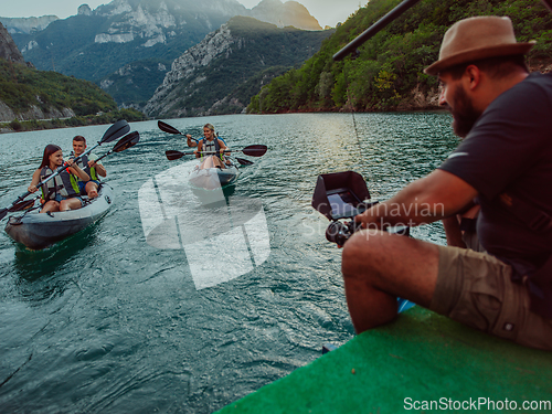 Image of A videographer recording a group of friends kayaking together and exploring river canyons