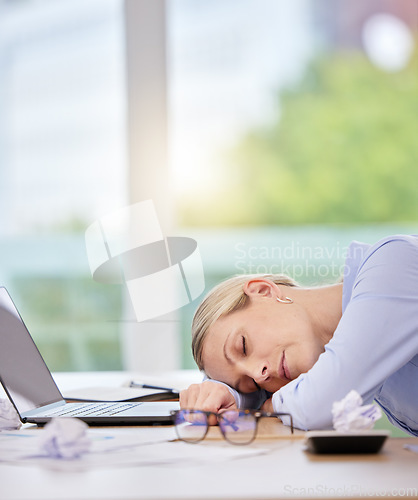 Image of Sleep, burnout and tired with a business woman sleeping at her desk in the office at work. Mental health, overworked and overtime with a mature female employee lying on her desk with her eyes closed