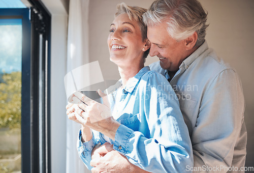 Image of Love, senior couple and retirement vacation while sharing a hug, drinking coffee and looking out window at home or in a hotel. Happy mature man and woman sharing a special bond and laughing together