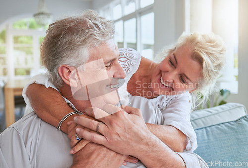 Image of Love, happy and senior couple hug and bonding on sofa, smile and relax in home together. Retirement, freedom and happy man and woman sharing a romantic embrace, enjoying conversation and relationship