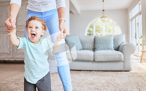 Image of Mother helping baby walk his first steps in living room for child development, growth and physical progress with lens flare. Young excited kid learning, walking with love and support from mom at home