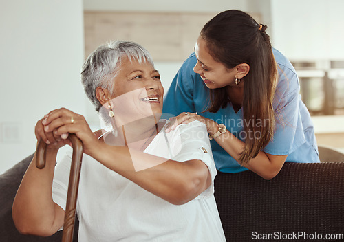 Image of Happy, relax and senior woman with caregiver smile while sitting on a living room sofa in a nursing home. Support, help and professional nurse or healthcare worker helping elderly lady or patient