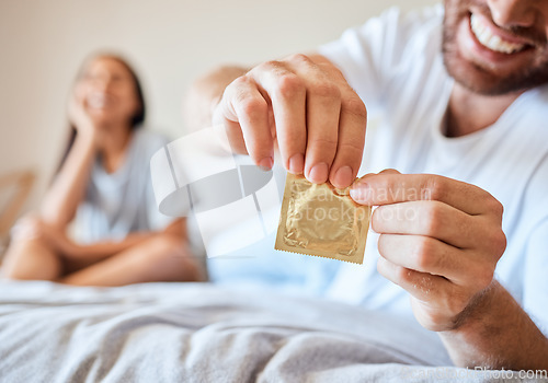 Image of Condom, sex and safety for sexual couple in bed together happy, smile and use protection. Happiness, love and man and woman open birth control contraceptive package to protect against std, sti or hiv