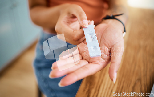 Image of Woman hands holding a covid test for safety, healthcare and medicare with a negative result. Closeup of a rapid coronavirus antigen testing kit for a medical diagnosis exam with a pcr device at home.