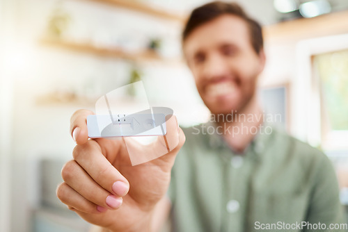 Image of Test, covid and positive with the hand of a man holding a testing kit and result in his home. Healthcare, medical and health with a male in his house with the corona virus, sickness or covid 19