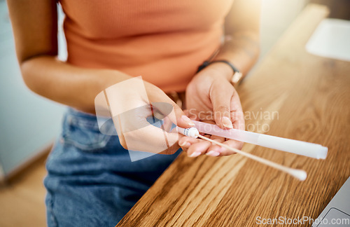 Image of Woman with kit for covid test in hand at desk, to analyse results and get diagnosis for wellness in home. Woman with cotton swab and tube at table, do PCR test for symptoms or sign of coronavirus