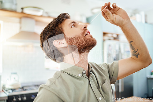 Image of Covid, sick and man in PCR test at home in the kitchen for self healthcare, wellness and safety. Male practicing safe health testing nose for corona virus in quarantine inspection at the house