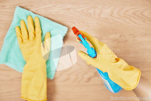 Image of Cleaning spray, glove hands and wipe table, counter and wood surface for housekeeping service at home. Above of maid, janitor and cleaner dust cloth chore, furniture shine and chemical bottle product